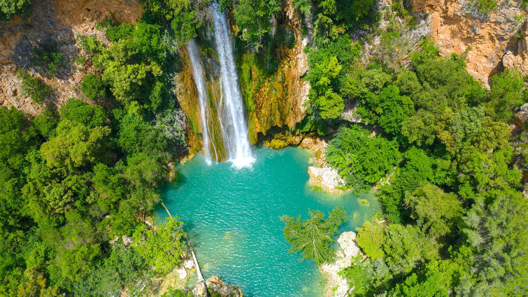 Cascades de la Côte d’Azur – vue aérienne d’une chute d’eau tombant dans une vasque turquoise entourée de forêt Cascades de la Côte d'Azur vue aérienne d'une chute d'eau dans une vasque turquoise entourée de forêt