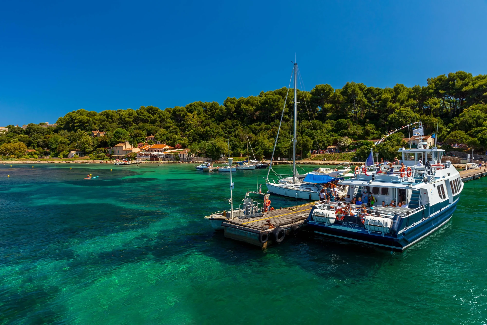 Que faire entre Antibes et Cannes – navette bateau accostant aux îles de Lérins, eaux turquoise et pinède Que faire entre Antibes et Cannes navette bateau accostant aux îles de Lérins eaux turquoise et pinède