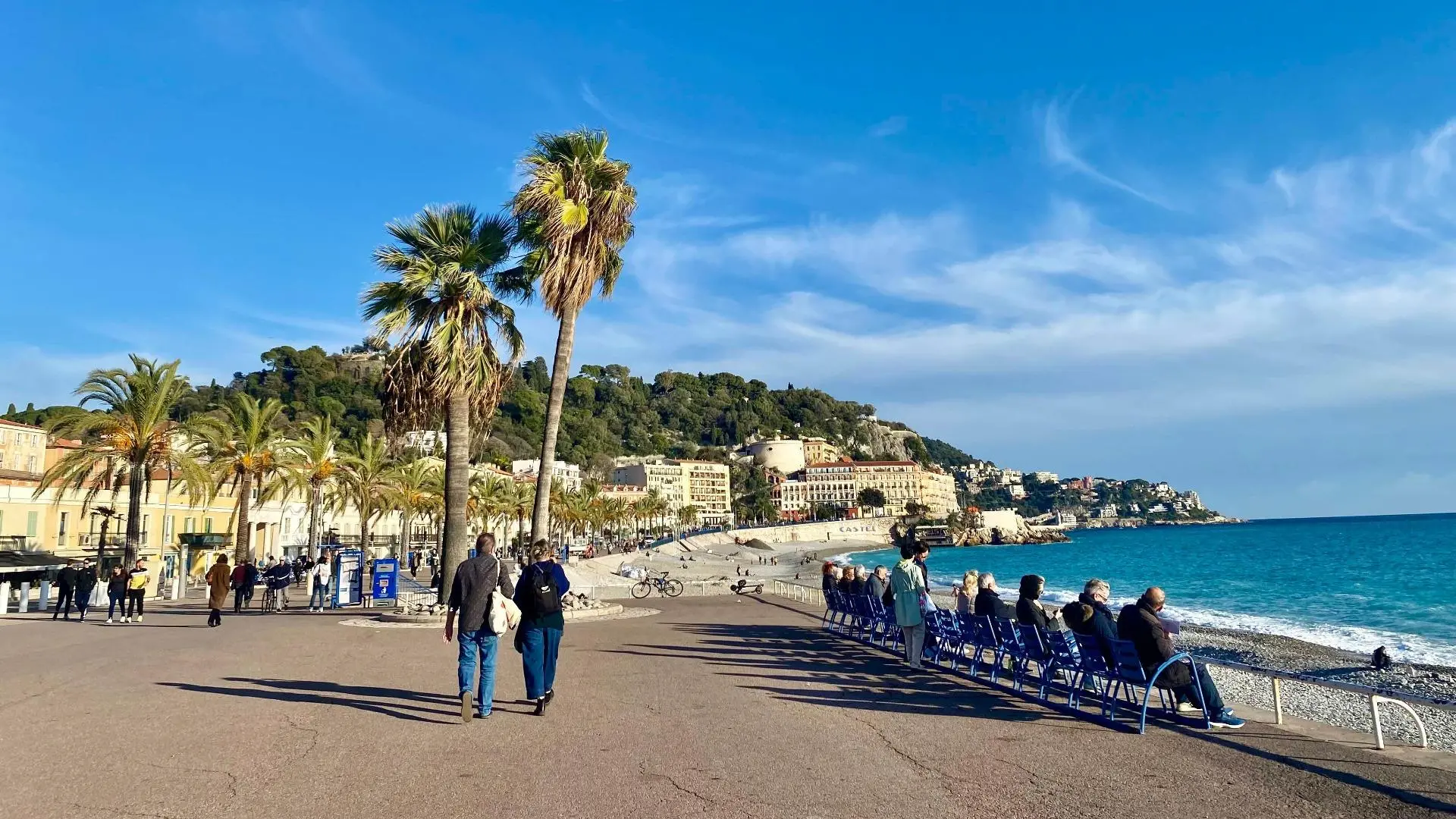 Chalets de Noël illuminés sous les palmiers face à la Méditerranée en décembre